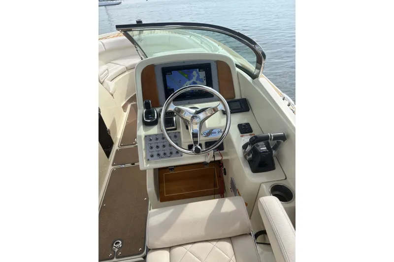 Slide: The Image of 2017 Chris-Craft Calypso 26 helm with steering wheel, navigation display, and controls. - 13