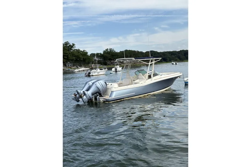 Slide: The Image of 2017 Chris-Craft Calypso 26 boat on calm water with twin outboard engines. - 5