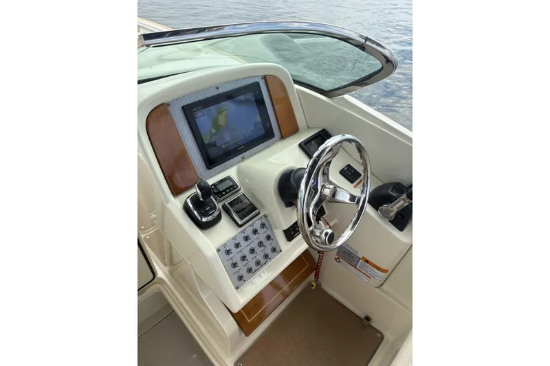 Slide: The Image of 2017 Chris-Craft Calypso 26 helm with modern controls and navigation display. - 14