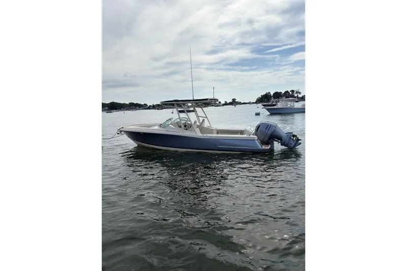 Slide: The Image of 2017 Chris-Craft Calypso 26 boat on calm water, side view. - 2
