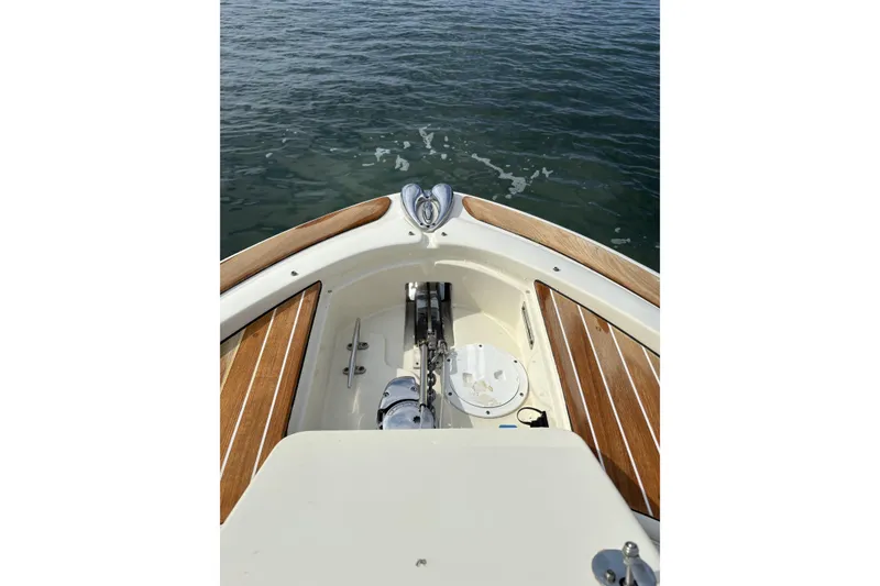 Slide: The Image of 2017 Chris-Craft Calypso 26 boat bow with teak accents on calm water. - 9