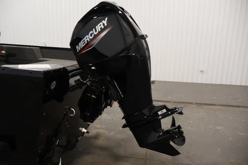 Slide: The Image of 2027 Lowe Fishing Machine 1625SC with Mercury outboard motor in a garage setting. - 19