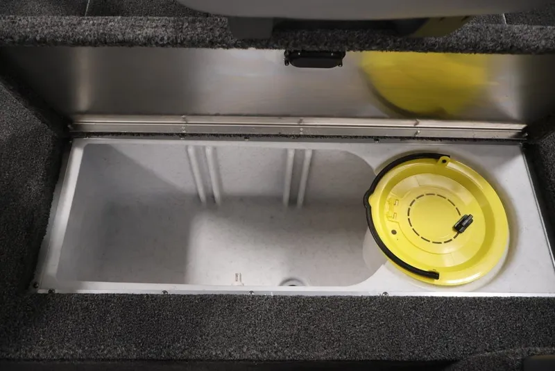Slide: The Image of 2027 Lowe Fishing Machine 1625SC livewell with yellow lid, open storage compartment. - 26