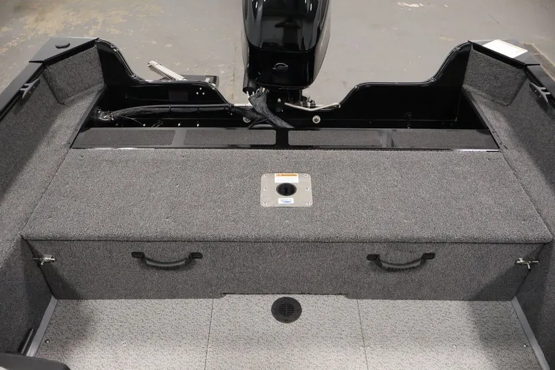 Slide: The Image of 2027 Lowe Fishing Machine 1625SC boat interior with storage compartments and motor. - 41