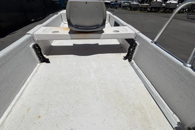 Slide: The Image of An empty boat deck with a seat and steering controls. - 27