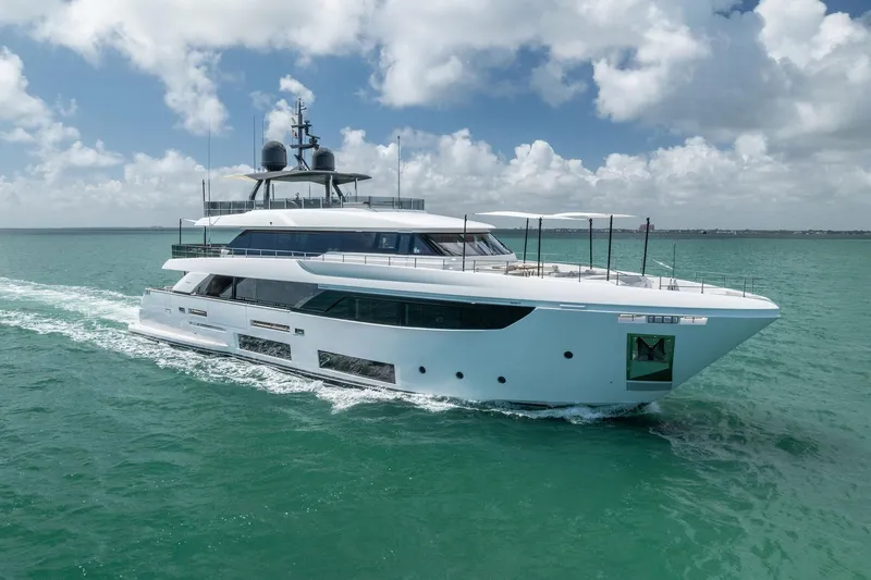 The Image of Luxurious 2023 Custom Line Navetta 33 yacht cruising on turquoise waters under a cloudy sky. - 0
