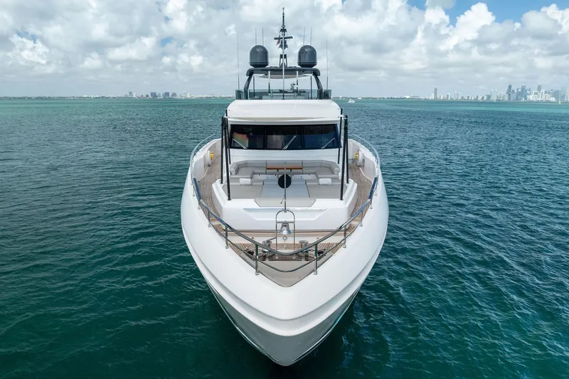 Slide: The Image of Luxurious 2023 Custom Line Navetta 33 yacht on open sea with city skyline backdrop. - 13