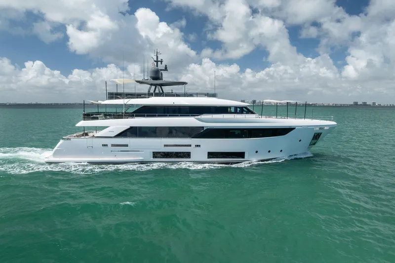 Slide: The Image of Luxurious 2023 Custom Line Navetta 33 yacht cruising on turquoise waters under a cloudy sky. - 3
