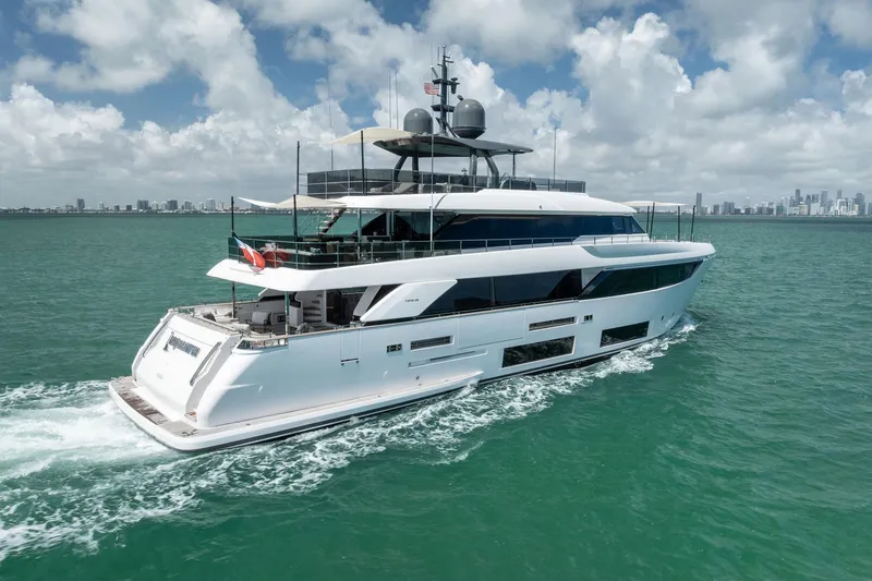 Slide: The Image of Luxurious 2023 Custom Line Navetta 33 yacht cruising on turquoise waters under a cloudy sky. - 5