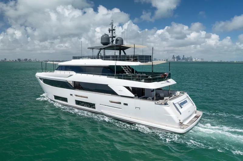 Slide: The Image of Luxurious 2023 Custom Line Navetta 33 yacht cruising on open sea with city skyline backdrop. - 9