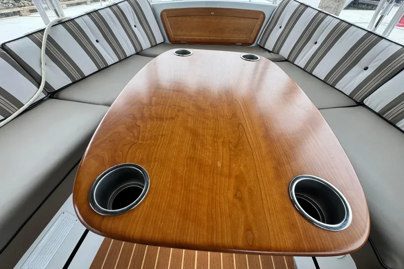 Slide: The Image of Interior of 2023 Duffy Bay Cruiser with wooden table and striped seating. - 3