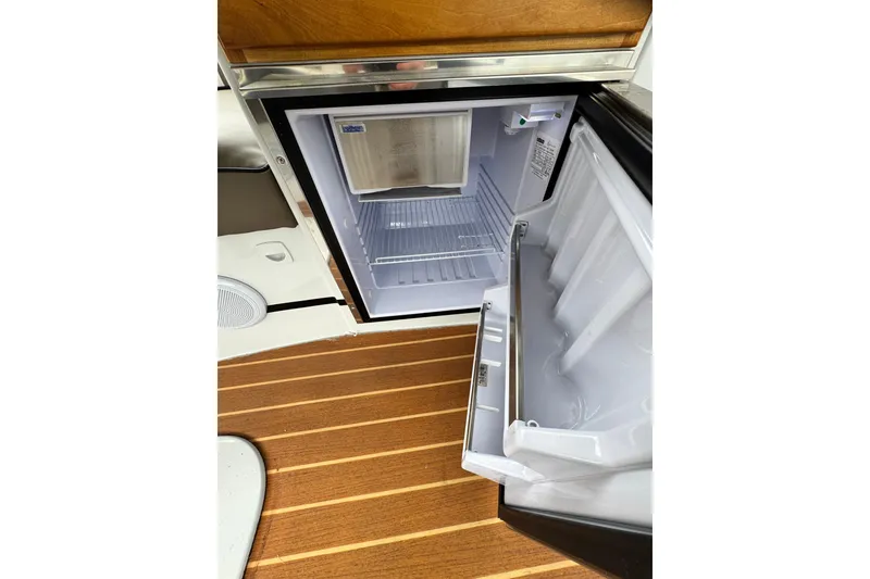 Slide: The Image of Open refrigerator on 2023 Duffy bay cruiser, showcasing interior and wooden flooring. - 4