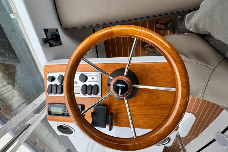 Slide: The Image of Steering wheel and controls of a 2023 Duffy Bay Cruiser boat. - 5