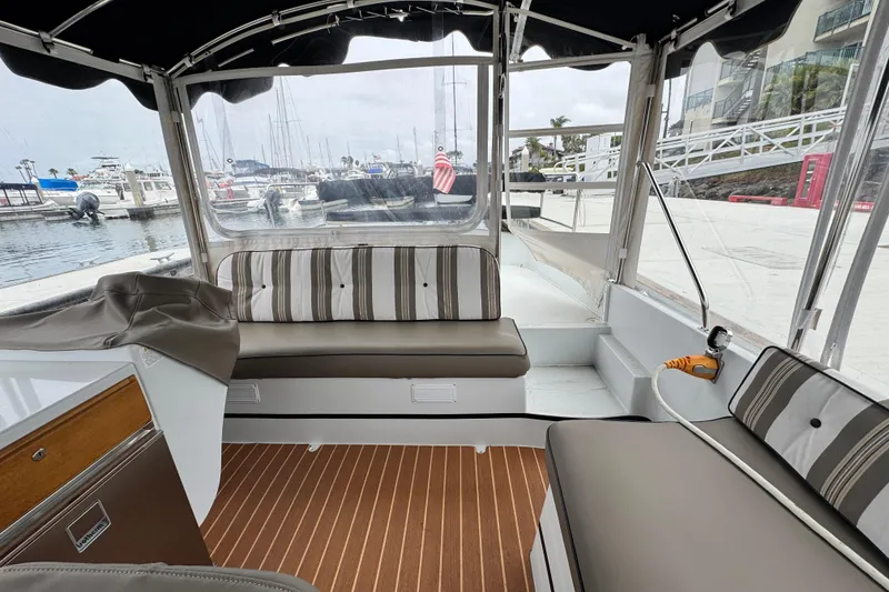 Slide: The Image of 2023 Duffy Bay Cruiser interior with striped seating, docked at marina. - 6