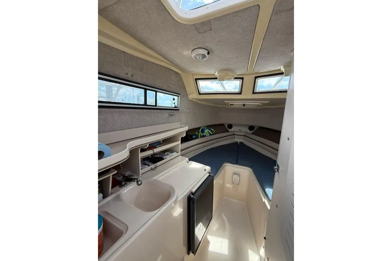 Slide: The Image of 1999 Grady-White Islander 268 cabin interior with kitchenette and seating area. - 12