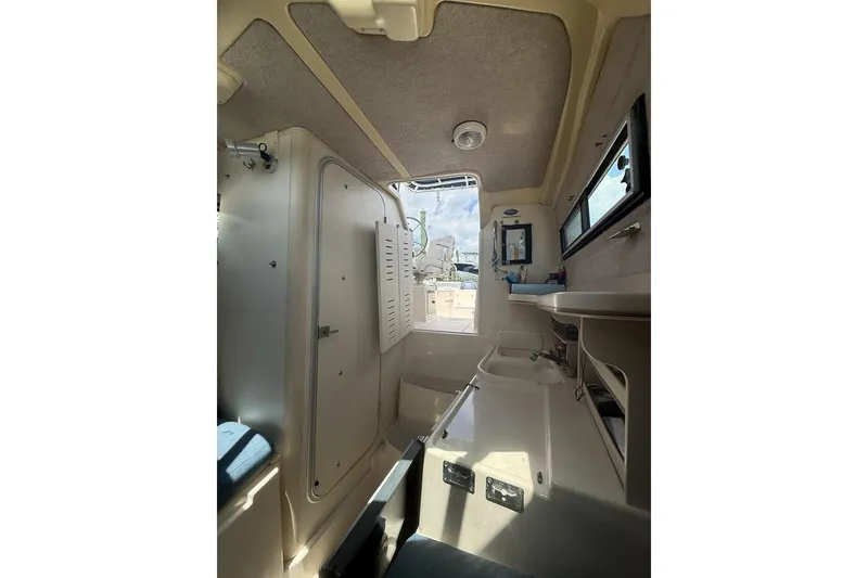Slide: The Image of Interior of 1999 Grady-White Islander 268 boat, featuring compact cabin amenities. - 14