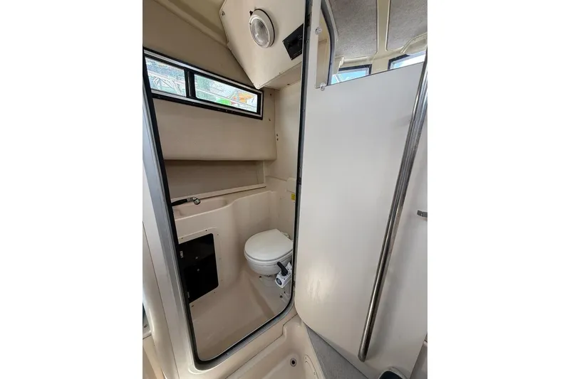 Slide: The Image of 1999 Grady-White Islander 268 boat bathroom interior with toilet and window. - 16