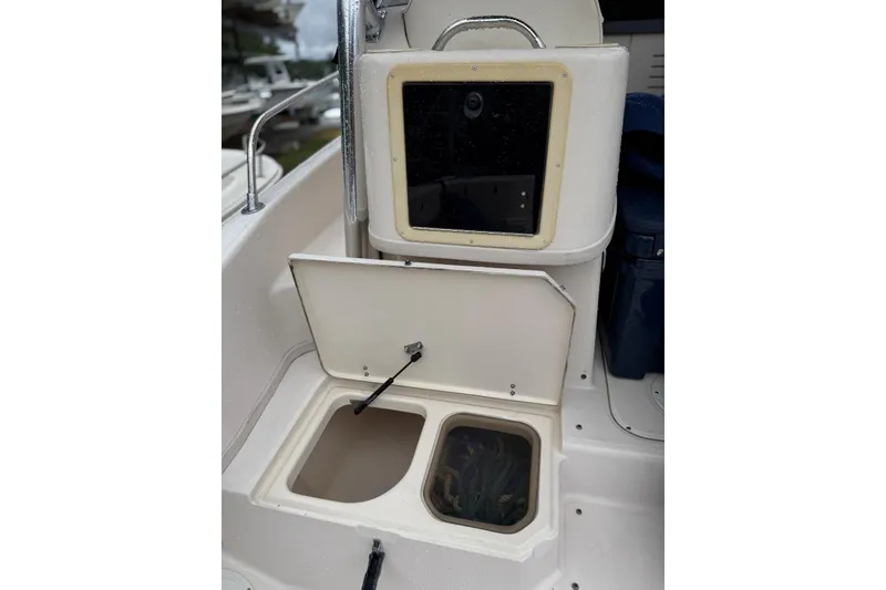 Slide: The Image of 1999 Grady-White Islander 268 boat storage compartments with open lids, showcasing interior space. - 18