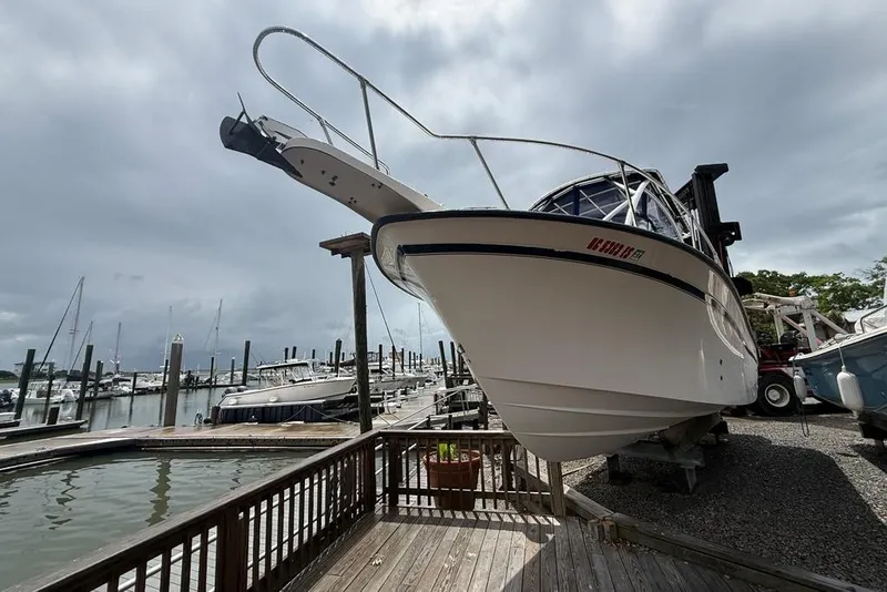 Slide: The Image of 1999 Grady-White Islander 268 boat docked at a marina under cloudy skies. - 4