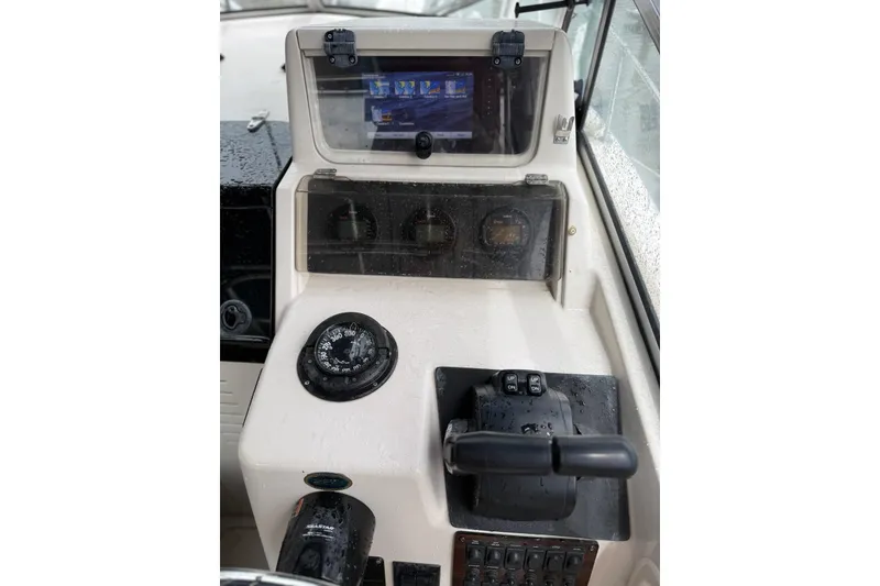 Slide: The Image of 1999 Grady-White Islander 268 helm with compass, throttle, and navigation display. - 9