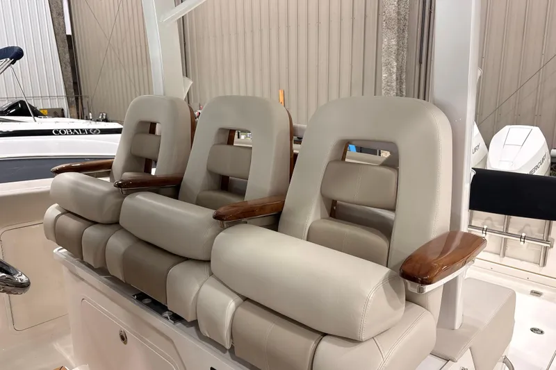 Slide: The Image of Luxury seating on 2026 Boston Whaler 380 Outrage boat, featuring plush cushions and wooden armrests. - 14
