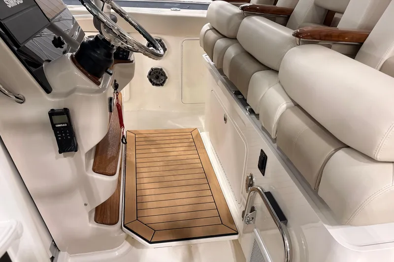 Slide: The Image of 2026 Boston Whaler 380 Outrage helm with luxurious seating and teak flooring. - 15