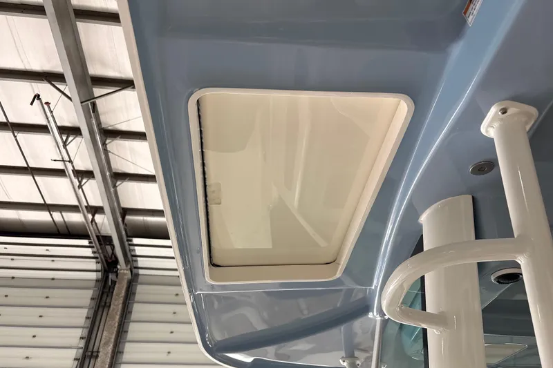 Slide: The Image of 2026 Boston Whaler 380 Outrage boat detail, featuring a sleek overhead compartment in a warehouse setting. - 17