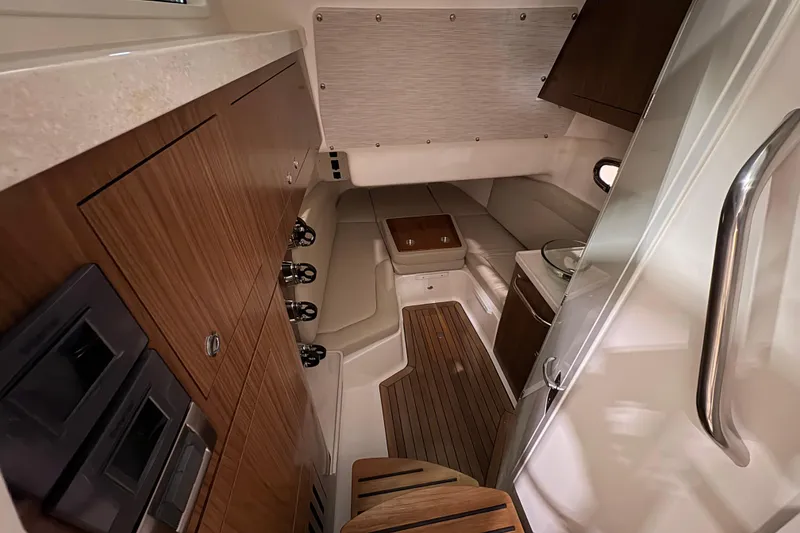Slide: The Image of Interior of 2026 Boston Whaler 380 Outrage, featuring elegant wood cabinetry and seating. - 19