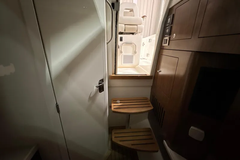 Slide: The Image of Interior view of 2026 Boston Whaler 380 Outrage cabin with wooden steps and seating. - 22