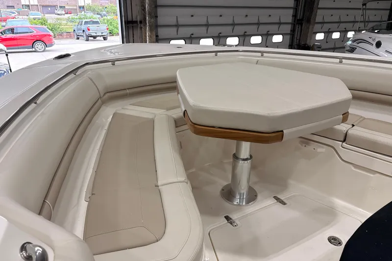 Slide: The Image of Interior of 2026 Boston Whaler 380 Outrage, featuring cushioned seating and a central table. - 25