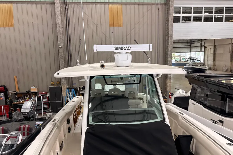 Slide: The Image of 2026 Boston Whaler 380 Outrage in a showroom, featuring advanced Simrad radar system. - 27