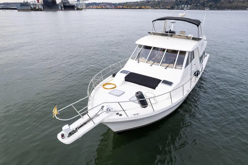 Slide: The Image of 2003 Meridian 490 Pilothouse yacht on calm water, featuring sleek design and spacious deck. - 1