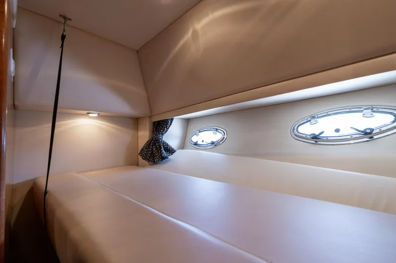 Slide: The Image of 2003 Meridian 490 Pilothouse cabin interior with portholes and cozy bedding. - 23