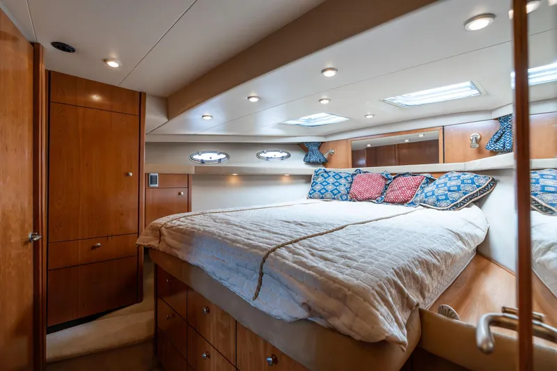 Slide: The Image of Luxurious bedroom interior of 2003 Meridian 490 Pilothouse yacht with cozy bedding and wood accents. - 25