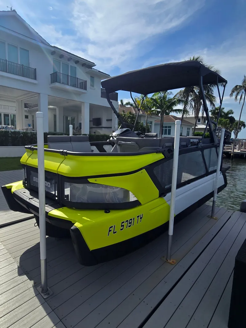 Slide: The Image of A yellow Sea-Doo Switch boat is docked at a pier in front of a house. - 1