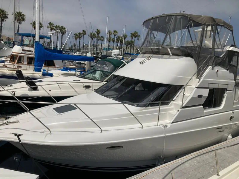 Slide: The Image of A 1999 Silverton 322 Motor Yacht docked in a marina, surrounded by other boats. - 1