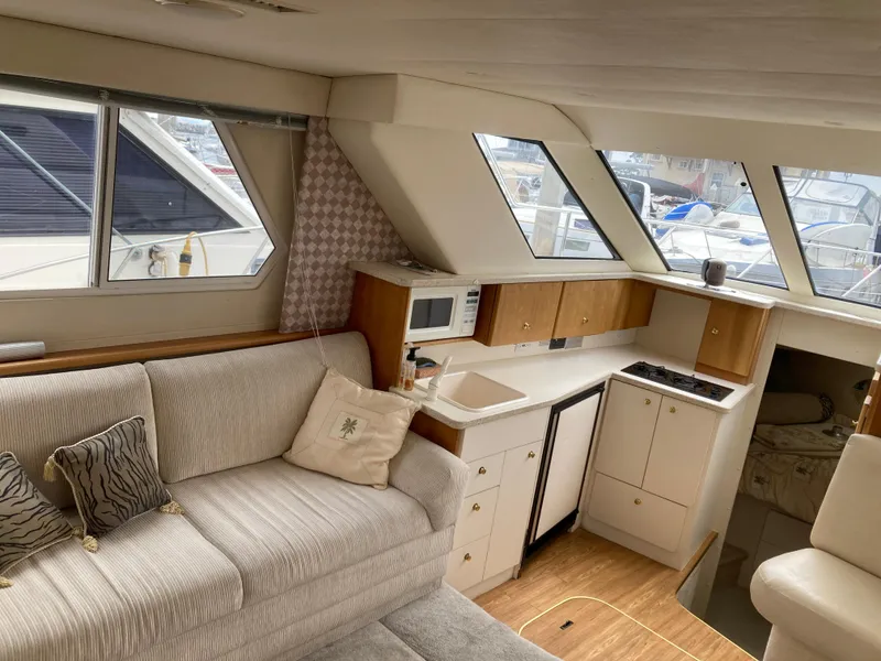 Slide: The Image of Interior of a 1999 Silverton 322 Motor Yacht with a sofa and kitchenette. - 17