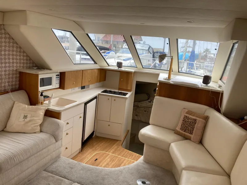 Slide: The Image of Interior of a 1999 Silverton 322 Motor Yacht with cozy seating and a kitchenette. - 18
