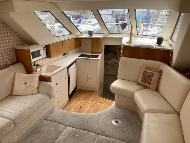 Slide: The Image of Interior of a 1999 Silverton 322 Motor Yacht with cozy seating area and kitchenette. - 19