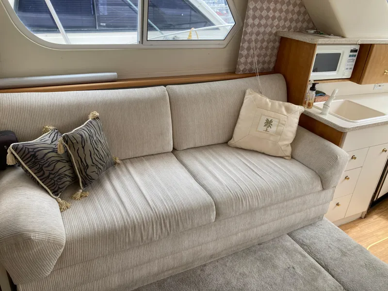 Slide: The Image of Interior of a 1999 Silverton 322 Motor Yacht with a beige sofa and cushions. - 20