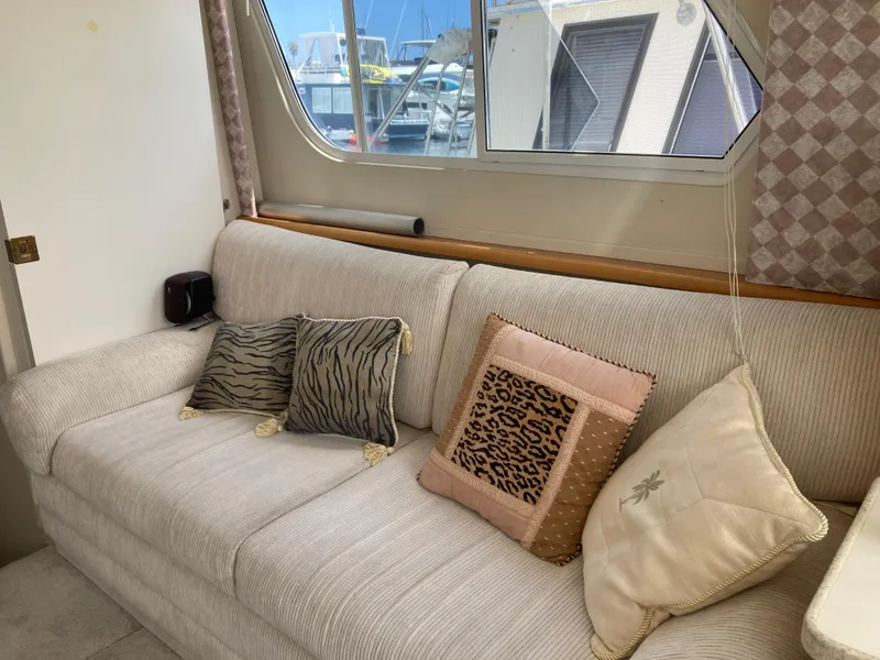 Slide: The Image of Interior of a 1999 Silverton 322 Motor Yacht with a beige sofa and patterned cushions. - 21