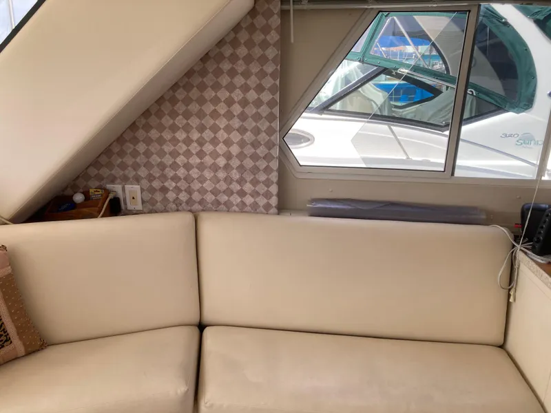 Slide: The Image of Interior of a 1999 Silverton 322 Motor Yacht with cream sofa and window. - 22