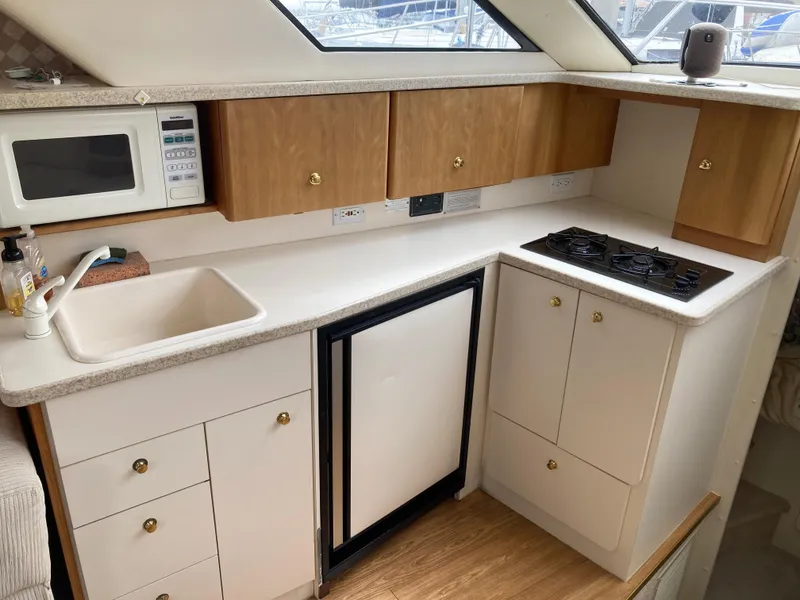 Slide: The Image of Interior view of a yacht kitchen with sink, stove, and microwave. - 23