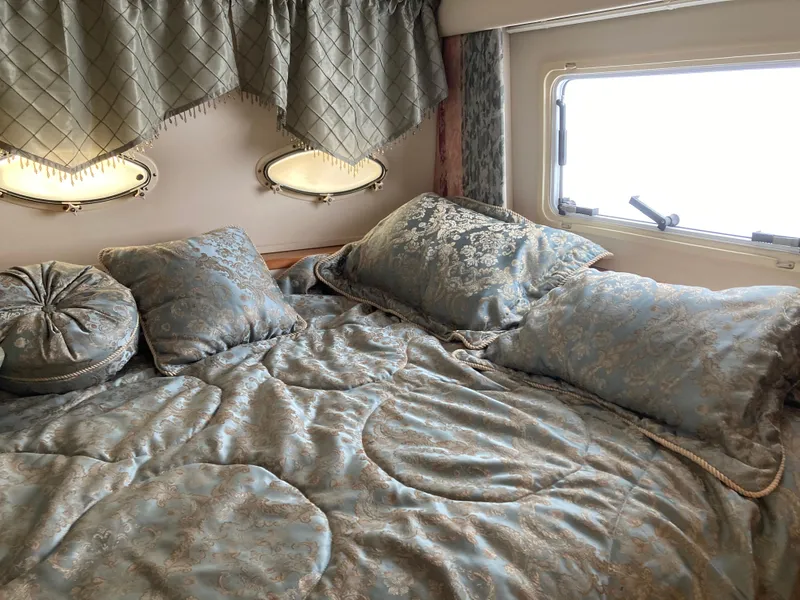 Slide: The Image of A cozy bedroom with a large bed and elegant pillows on a yacht. - 27