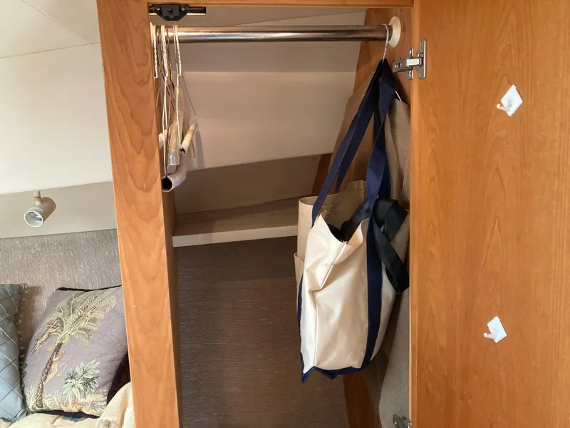Slide: The Image of A closet in a yacht with hangers and a bag. - 28