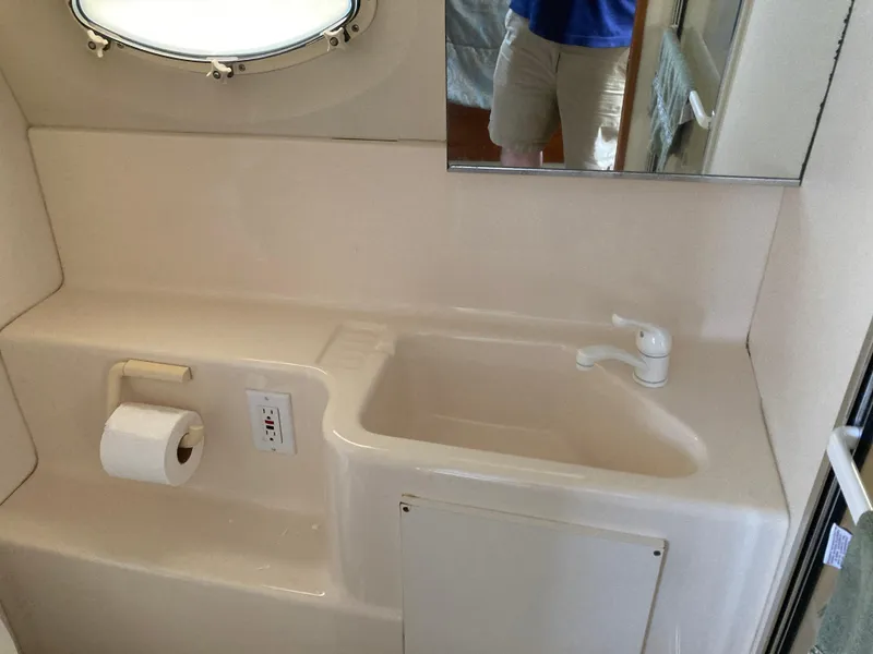 Slide: The Image of A yacht bathroom with a sink and mirror. - 29