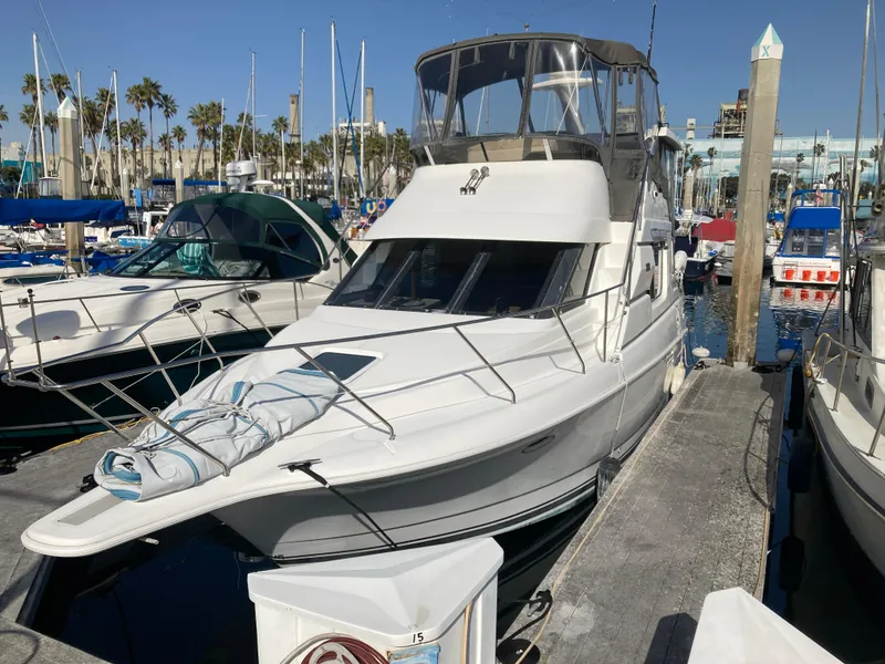 Slide: The Image of A 1999 Silverton 322 Motor Yacht docked in a marina, surrounded by other boats. - 4