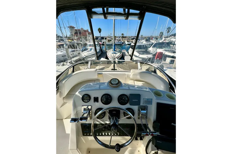 Slide: The Image of 1999 Silverton 322 Motor Yacht helm view, showcasing marina and docked boats. - 36
