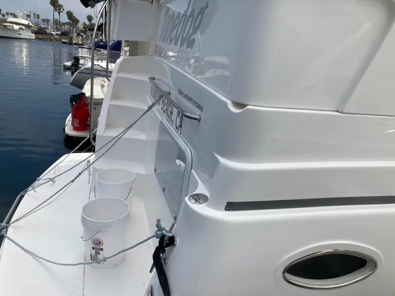 Slide: The Image of A white motor yacht docked at a marina, with buckets on the deck. - 7