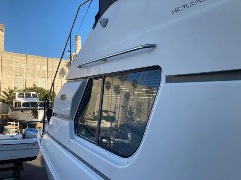 Slide: The Image of A 1999 Silverton 322 Motor Yacht docked, with buildings in the background. - 8